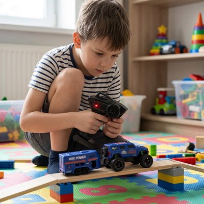 Voiture télécommandée enfant bleue roule sur pont dans salle jeu