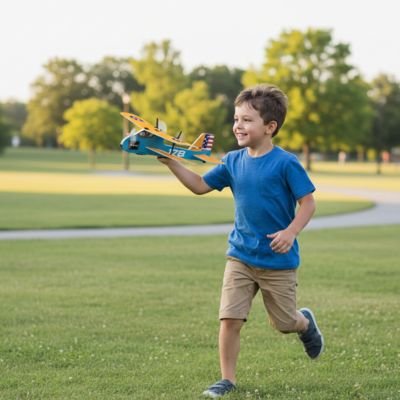 garçon court au parc en tenant en main avion télécommandé 
