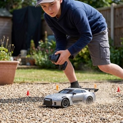 Voiture télécommandée enfant roule en vitesse sur gravier dans jardin